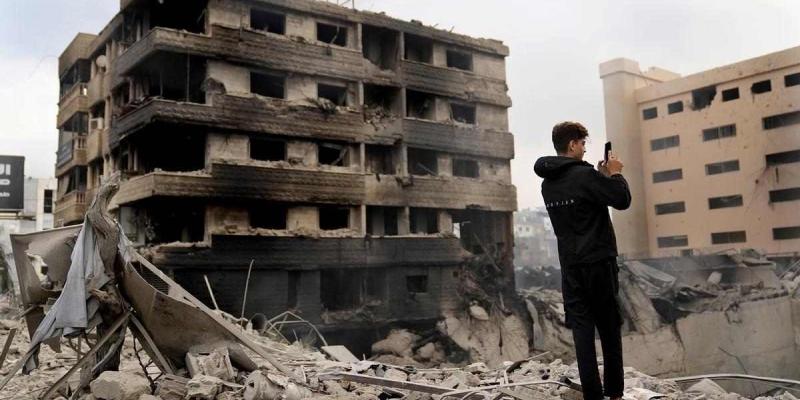 Un hombre toma fotos con el móvil de edificios destruidos tras un ataque aéreo de Israel en Dahiyeh, Beirut, Líbano. 