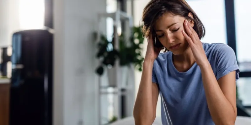Mujer con Síndrome de Ménière tocándose la cabeza