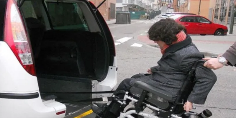 Taxi adaptado y una persona con discapacidad subiendo
