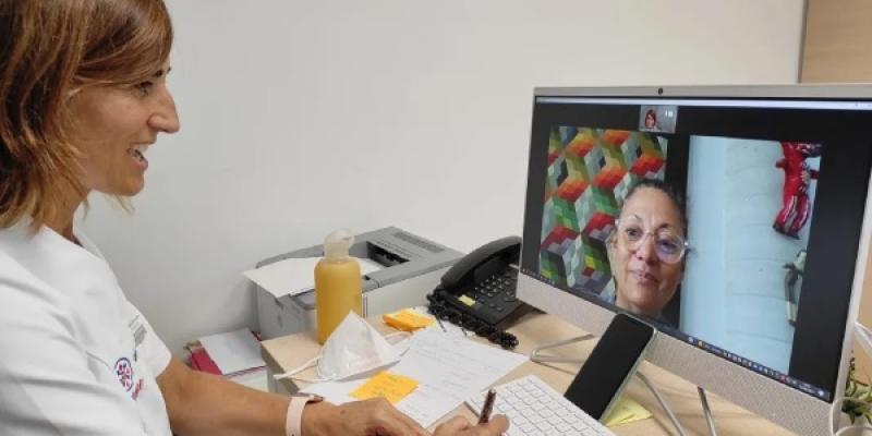 Médico con su paciente en una consulta de telerrehabilitación hablando a través de una pantalla de ordenador