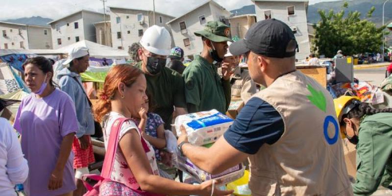 Un voluntario reparte material de higiene personal 