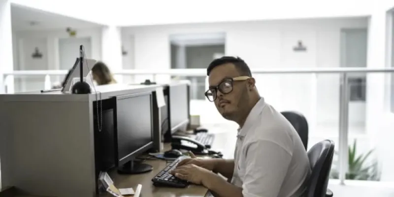 Un trabajador con discapacidad intelectual en la recepción de un hospital