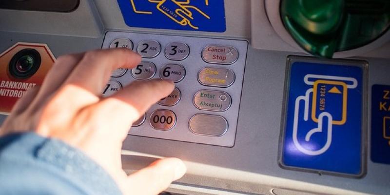 Un joven realiza una transacción bancaria en un cajero