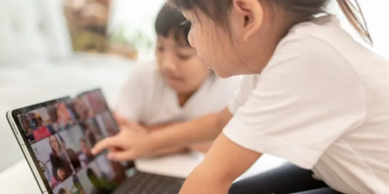 Dos niños miran a una pantalla 