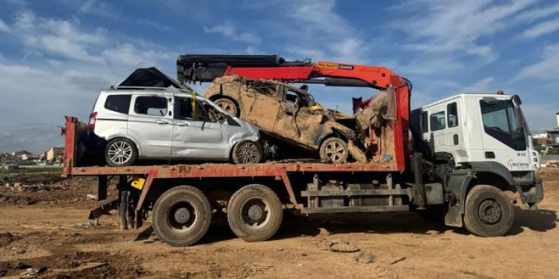 Coches retirados de una campa en dirección a un desguace