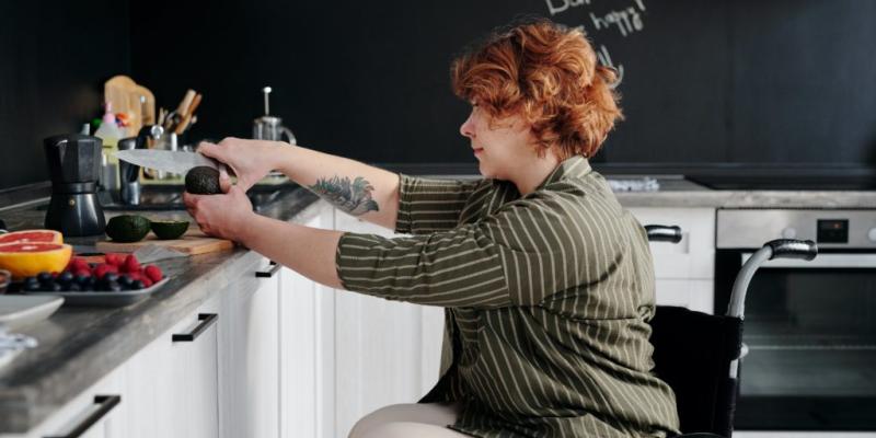 Mujer en silla de ruedas realizando tareas domésticas