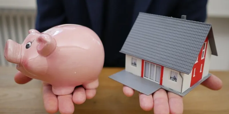 Imagen con una hucha y una casa de juguete