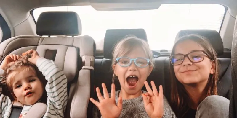 Tres niñas de diferentes edades viajan en el asiento trasero de un coche
