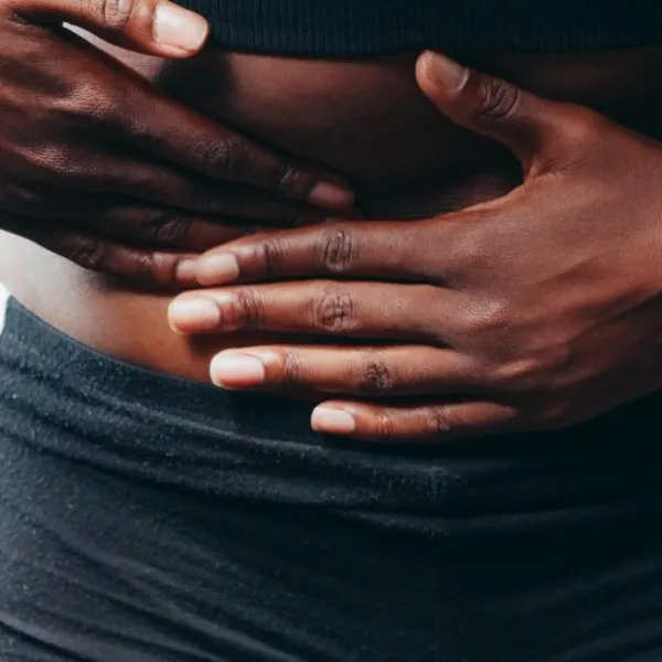 Chica tocándose la tripa con dolor