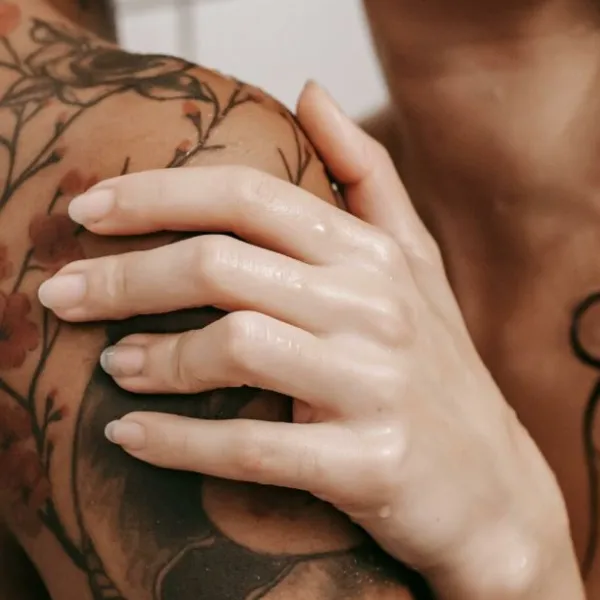 Dos personas abrazándose desnudas en la ducha
