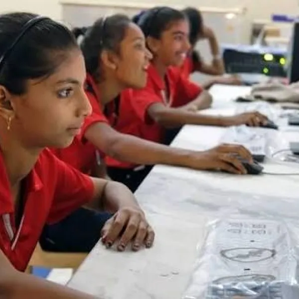 Niñas aprendiendo a usar herramientas digitales en una escuela en India.
