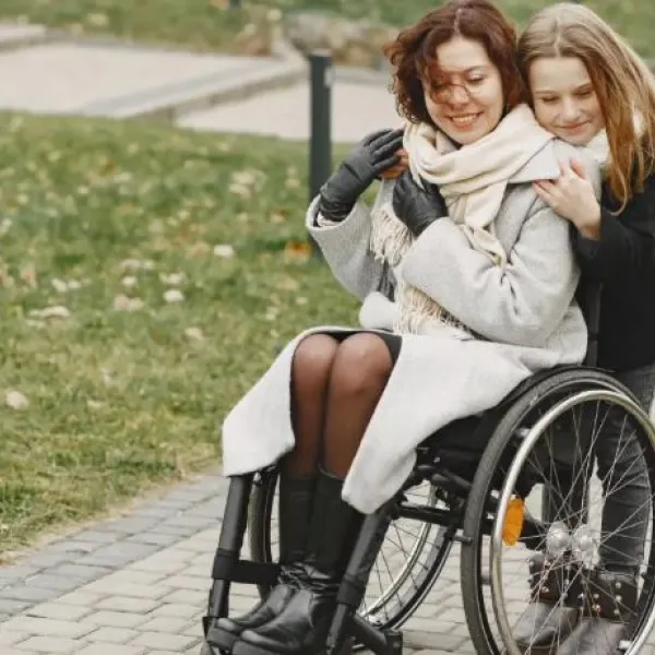 Una madre con discapacidad pasea junto a su hija.
