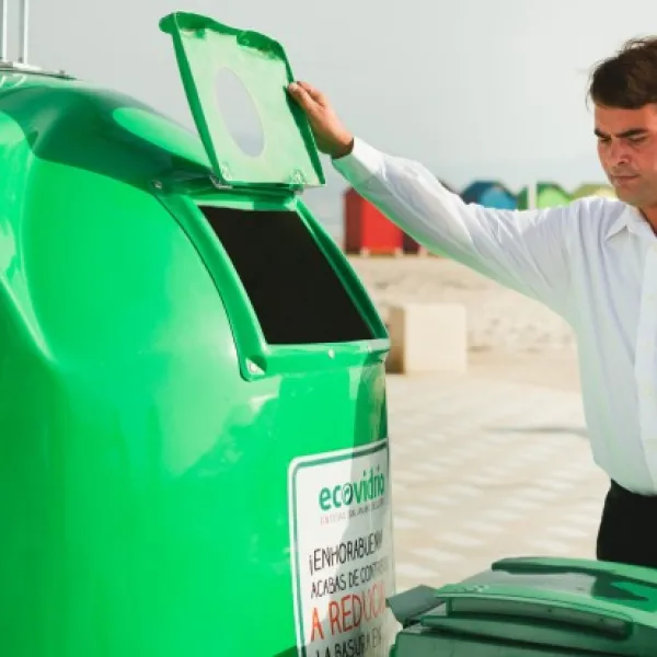 Un hombre se dispone a reciclar vidrio cerca de una playa