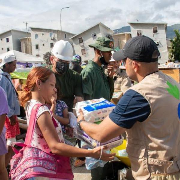 Un voluntario reparte material de higiene personal