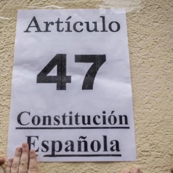 28 de enero de 2016. Activistas pegan un cartel con el artículo de la Constitución que recoge el derecho a la vivienda en el exterior de un edificio donde estaba previsto el desahucio de Nerea.