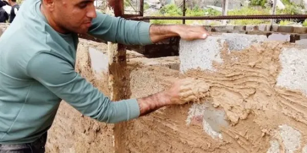Un palestino construye un refugio para su familia utilizando los escombros de su casa destruida y el barro.
