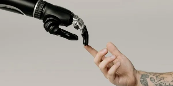 Mano de un robot y mano de una persona juntando sus dedos 
