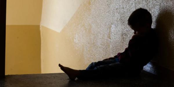 Silueta de niño contra una pared a contraluz