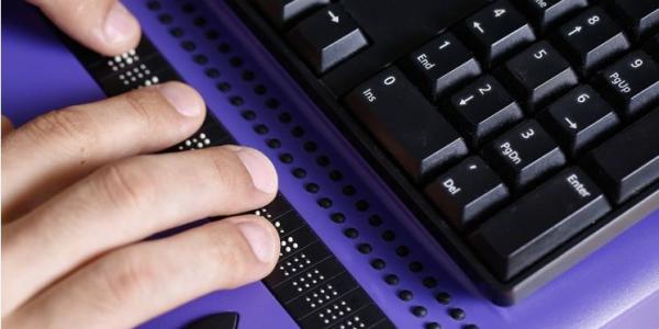 Manos de una persona con un teclado accesible