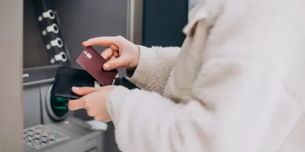 Una mujer sacando dinero del cajero 