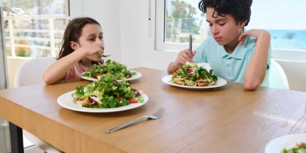 Dos menores comen comida vegetariana 