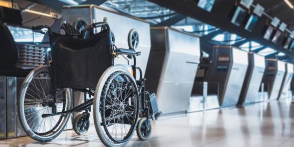  Una silla de ruedas junto a los mostradores de facturación de un aeropuerto