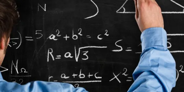Un profesor escribe fórmulas matemáticas en la pizarra 