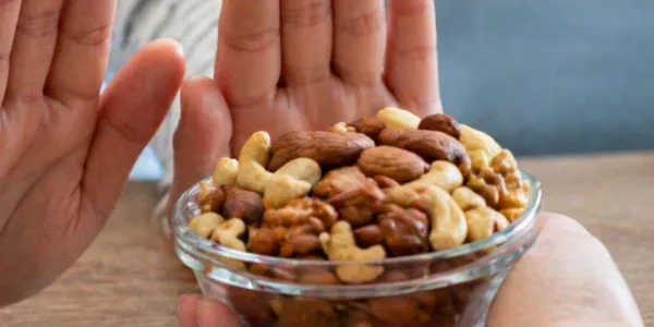 Manos de una persona apartando un bol de frutos secos