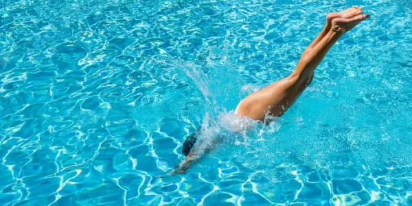 Mujer tirándose de cabeza a la piscina