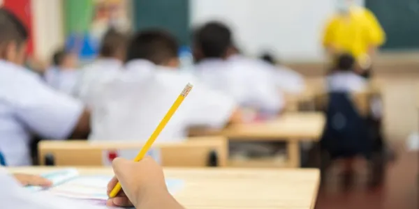 Un alumno escribe en clase 
