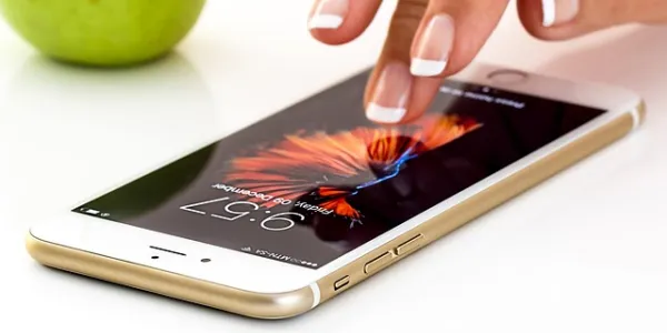 Mano de una chica manipulando un teléfono móvil