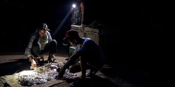 Analyn Fedelis y dos personas más clasifican su pesca. 