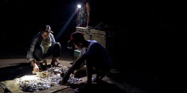 Analyn Fedelis y dos personas más clasifican su pesca. 