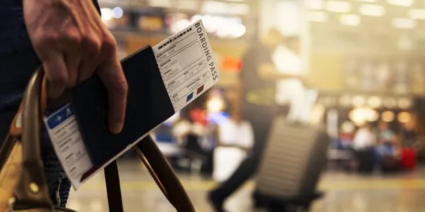Mano de una persona sujetando su pasaporte en el aeropuerto