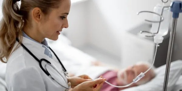 Una enfermera atiende a un paciente con la infusión intravenosa 