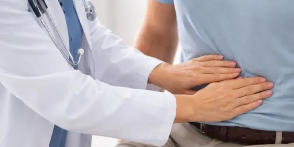 Manos de una doctora palpando el cáncer de colon de un paciente