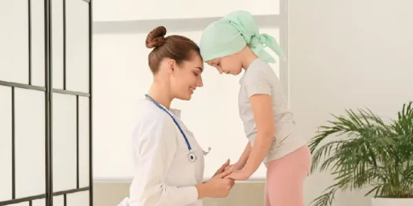 Una sanitaria, junto a una paciente de cáncer 