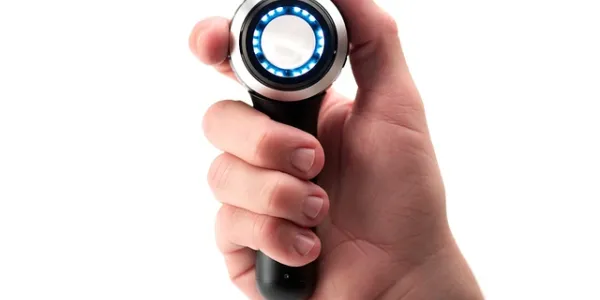 Una mano sujeta un dermatoscopio 