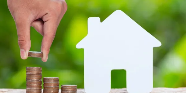 Imagen de una casa con una montaña de dinero