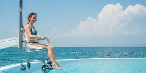 Una mujer accede en silla de ruedas a una piscina 