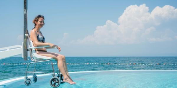 Una mujer accede en silla de ruedas a una piscina 