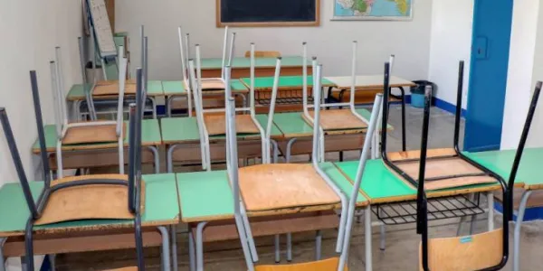 Aula de colegio cerrada con todas las sillas sobre las mesas