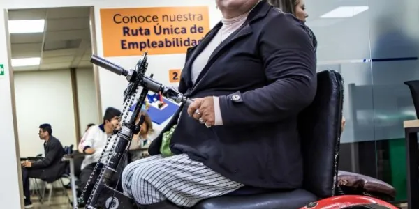 Señora en silla de ruedas trabajando en una oficina de Colombia