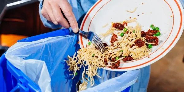 Plato con comida que está tirándose a la basura