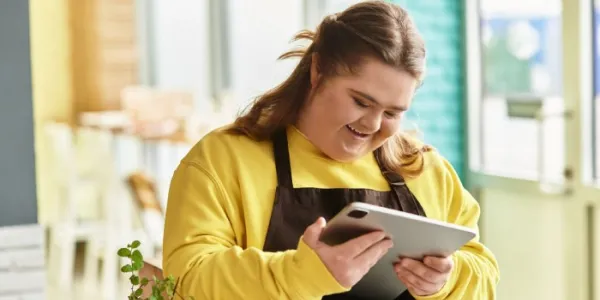 Una mujer con discapacidad maneja una tablet en su trabajo 