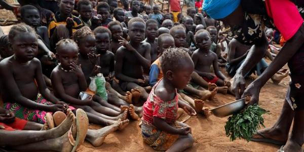 Asha Kano Kavi sirve hojas silvestres hervidas como alimento a niños huérfanos en el campo de desplazados internos de Bruam, al sur de Sudán, el pasado junio. 