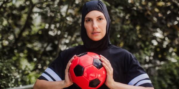 Mujer con hiyab sosteniendo una pelota