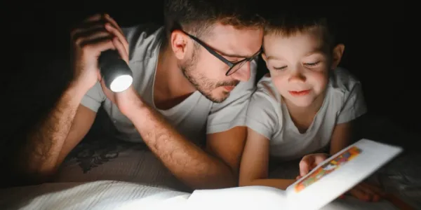 Niño leyendo un cuento con su padre