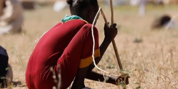 Una joven cava agujeros para hacer un refugio para su familia en un campamento de desplazados en Tawila donde cientos de El Fasher han huido en busca de seguridad.