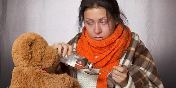 Chica tomando jarabe para mejorar las defensas con un resfriado / Pixabay